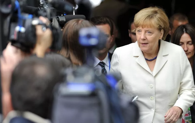 German Chancellor Angela Merkel (R) arrives for a meeting of European Popular Parties (EPP), on July 12, 2015, in Brussels. The EU cancelled a full 28-nation summit on July 12 to decide whether Greece stays in the European single currency as a divided eurozone struggled to reach a reform-for-bailout deal. AFP PHOTO / JEAN-CHRISTOPHE VERHAEGEN