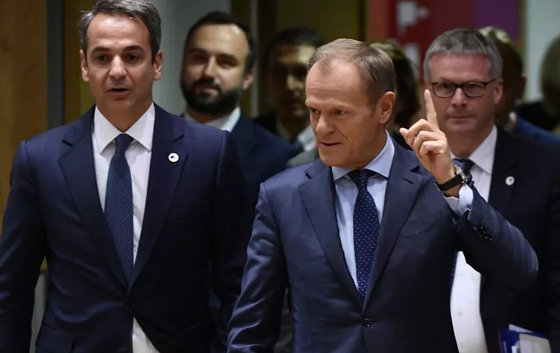 European Council President Donald Tusk (R) gestures to Greek Prime Minister Kyriakos Mitsotakis as they arrive for an European Union Summit at European Union Headquarters in Brussels on October 17, 2019. (Photo by John THYS / AFP)