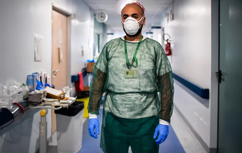 Male nurse Omar Semlali poses at the end of his shift on April 27, 2020 at the COVID-19 ward of the Cremona hospital, Lombardy, during the country's lockdown aimed at curbing the spread of the COVID-19 infection, caused by the novel coronavirus. (Photo by Miguel MEDINA / AFP)