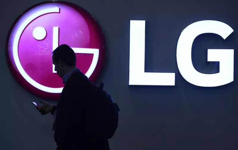 A man walks by the LG stand at the Mobile World Congress (MWC), the world's biggest mobile fair, on February 26, 2018 in Barcelona. - The Mobile World Congress is held in Barcelona from February 26 to March 1. (Photo by Josep LAGO / AFP)