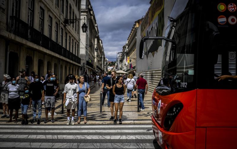 People wait to cross a street in downtown Lisbon on September 13, 2021. - Portugal ended today the Covid-19 mesure of mandatory use of mask in the streets. (Photo by PATRICIA DE MELO MOREIRA / AFP)