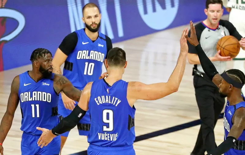 LAKE BUENA VISTA, FLORIDA - AUGUST 18: James Ennis III #11, Nikola Vucevic #9 and Terrence Ross #31 of the Orlando Magic celebrate after beating the Milwaukee Bucks in Game One in the first round of the NBA playoffs at The Field House at ESPN Wide World Of Sports Complex on August 18, 2020 in Lake Buena Vista, Florida. NOTE TO USER: User expressly acknowledges and agrees that, by downloading and/or using this Photograph, user is consenting to the terms and conditions of the Getty Images License Agreement. (Photo by Kim Klement-Pool/Getty Images)