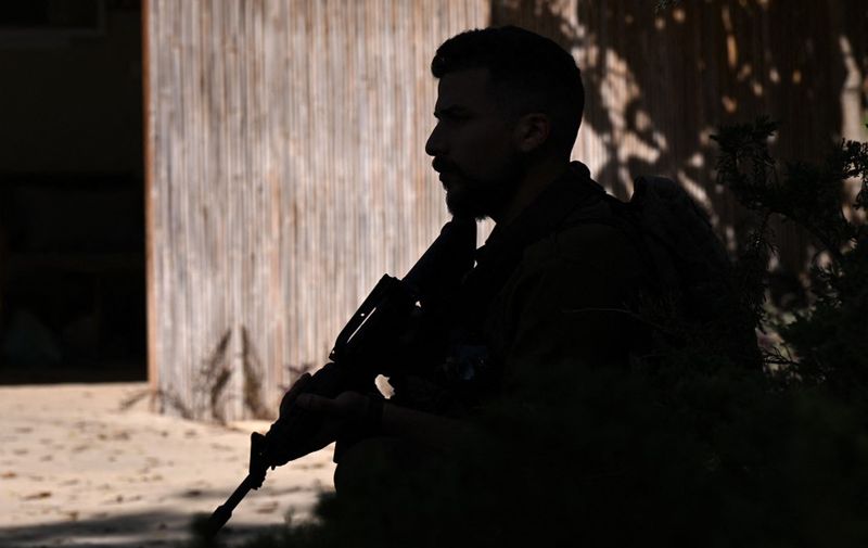 A picture taken during a media tour organised by the Israeli military shows a soldier securing a position at the Nir Oz kibbutz, one of the Israeli communities near the Gaza Strip attacked on October 7 by the Palestinian militant group Hamas, on October 30, 2023. Thousands of civilians, both Palestinians and Israelis, have died since October 7, 2023, after Palestinian Hamas militants based in the Gaza Strip entered southern Israel in an unprecedented attack triggering a war declared by Israel on Hamas with retaliatory bombings on Gaza. (Photo by YURI CORTEZ / AFP)