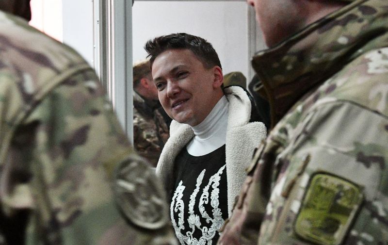Nadiya Savchenko greets her supporters during a hearing in Kiev's district court on March 23, 2018. - Ukrainian MP Nadiya Savchenko, once hailed as a symbol of resistance against Russia, declared a hunger strike on Friday after she was detained a day before over accusations she plotted a terrorist attack in Kiev. "I am starting a hunger strike from today," Savchenko said during a court hearing which is expected to opt whether she would go free or remain behind bars pending trial. (Photo by Genya SAVILOV / AFP)