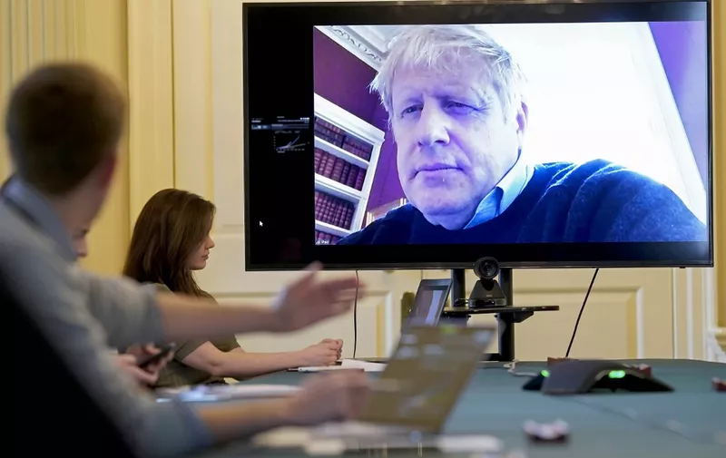 A handout picture released by 10 Downing Street, the office of the British prime minister on March 28, 2020, shows an image of Britain's Prime Minister Boris Johnson on a screen as he remotely chairs the morning novel coronavirus Covid-19 meeting by video link, in Downing Street in central London. - The two men leading Britain's fight against the coronavirus -- Prime Minister Boris Johnson and his Health Secretary Matt Hancock -- both announced Friday they had tested positive for COVID-19, as infection rates accelerated and daily death rate rose sharply. (Photo by - / 10 Downing Street / AFP) / RESTRICTED TO EDITORIAL USE - MANDATORY CREDIT "AFP PHOTO / 10 DOWNING STREET / HANDOUT" - NO MARKETING - NO ADVERTISING CAMPAIGNS - DISTRIBUTED AS A SERVICE TO CLIENTS
