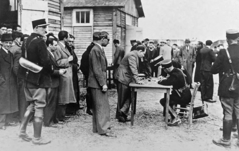 Picture taken on May 1941 at Pithiviers showing foreign Jews who get registered by French policemen after their arrival in the transit camp. These registration was the beginning of the deportation process towards the extermination camps in Germany and in East Europe. (Photo by - / AFP)