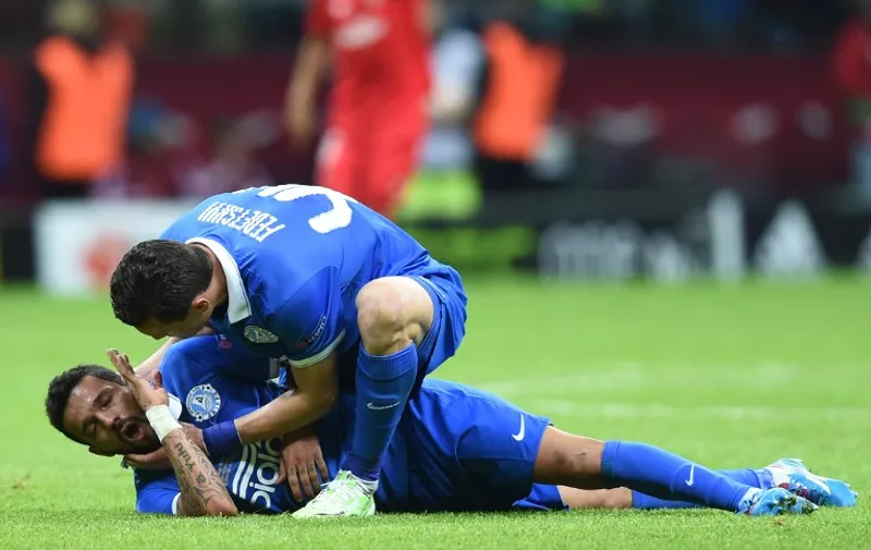 Dnipro's Brazilian forward Matheus (99) is helped by Dnipro's defender Artem Fedetskiy after being injured during the UEFA Europa League final football match between FC Dnipro Dnipropetrovsk and Sevilla FC at the Narodowy stadium in Warsaw, Poland on May 27, 2015.      AFP PHOTO / PIOTR HAWALEJ