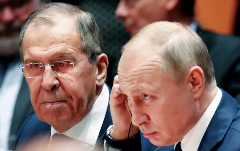 Russian President Vladimir Putin (R) and Russia's acting Foreign Minister Sergei Lavrov listen during a Peace summit on Libya at the Chancellery in Berlin on January 19, 2020. - Held under the auspices of the UN, the summit's main goal was to get foreign powers wielding influence in the region to stop interfering in the war -- be it through the supply of weapons, troops or financing. (Photo by HANNIBAL HANSCHKE / POOL / AFP)
