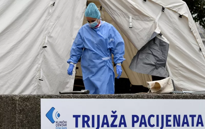 A Montenegrin medical worker walk outside a triage tent at the Medical center in capital Podgorica, on March 27, 2020, amid the outbreak of COVID-19, caused by the coronavirus. - Montenegro, which has detected 70 confirmed infections of COVID-19 so far, issued strict measures, including a closure of schools, ban on public gatherings, and restrictions of land and sea passenger transport. (Photo by Savo PRELEVIC / AFP)
