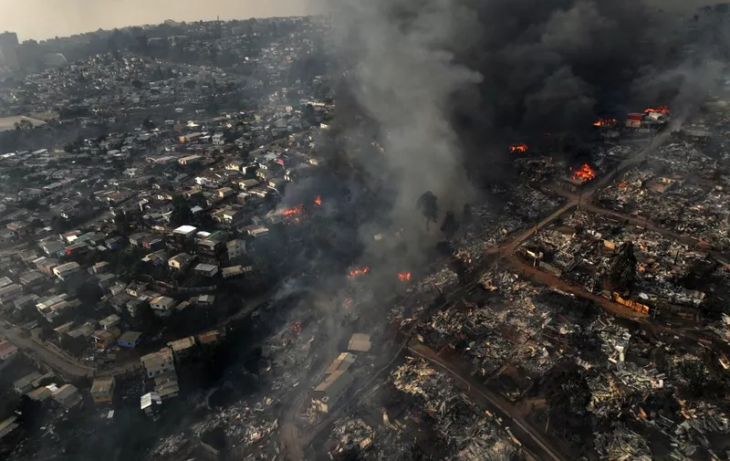 Aerial view of the forest fire that affects the hills of the city of Viña del Mar in the Las Pataguas sector, Chile, taken on February 3, 2024. The region of Valparaoso and Viña del Mar, in central Chile, woke up on Saturday with a partial curfew to allow the movement of evacuees and the transfer of emergency equipment in the midst of a series of unprecedented fires, authorities reported. (Photo by Javier TORRES / AFP)