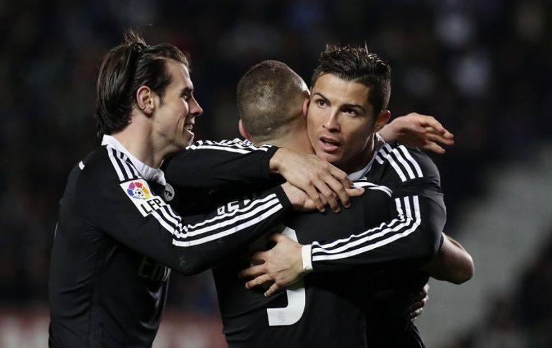 Real Madrid's French forward Karim Benzema (C) celebrates his goal  with Real Madrid's Portuguese forward Cristiano Ronaldo (R) and Real Madrid's Welsh forward Gareth Bale (L) during the Spanish league football match Elche FC vs Real Madrid at the Martin Valero stadium in Elche on February 22, 2015. AFP PHOTO/ JOSE JORDAN