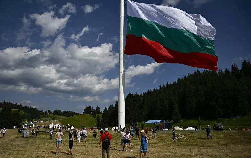 People watch the rising of a large Bulgarian flag during preparations ahead of the inauguration of an 111 m / 364 ft flagpole at Rozhen meadows near the city of Smolyan, some 80km south of Plovdiv, on July 13, 2023. The 111-metre (364-foot) pole, inaugurated in the Rhodope mountains by hoisting a 1,110 square-metre flag, is meant to symbolise Bulgaria's territory of 111,000 square kilometres, and is the highest such mast in the European Union. (Photo by Nikolay DOYCHINOV / AFP)
