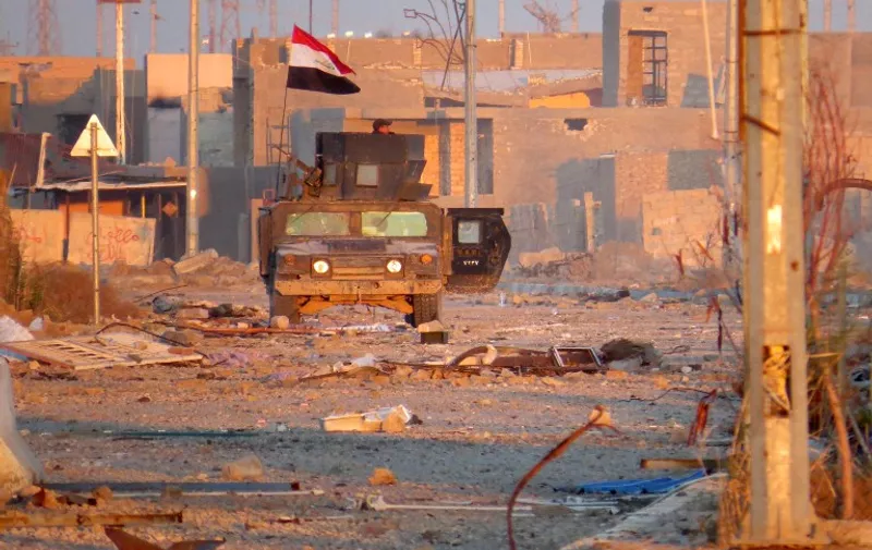 A member of Iraq's counter-terrorism forces monitors his surrounding in a street in Ramadi's Dhubbat neighberhood, adjacent to Hoz neighbourhood, on December 25, 2015. Elite forces from the counter-terrorism service (CTS) faced limited resistance when they punched into central Ramadi four days earlier, in a final push to retake the city they lost to the Islamic State (IS) group in May. 
 / AFP / STR