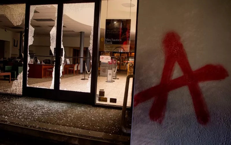 A Mechanics Bank is seen vandalised after protesters passed through in Berkeley, California on February 1, 2017. 
Violent protests erupted on February 1 at the University of California at Berkeley over the scheduled appearance of a controversial editor of the conservative news website Breitbart. / AFP PHOTO / Josh Edelson