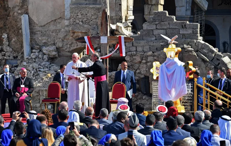 Pope Francis (C-L) speaks at the ruins of the Syriac Catholic Church of the Immaculate Conception (al-Tahira-l-Kubra), in the old city of Iraq's northern Mosul on March 7, 2021. - Pope Francis, on his historic Iraq tour, visits today Christian communities that endured the brutality of the Islamic State group until the jihadists' "caliphate" was defeated three years ago (Photo by Vincenzo PINTO / AFP)