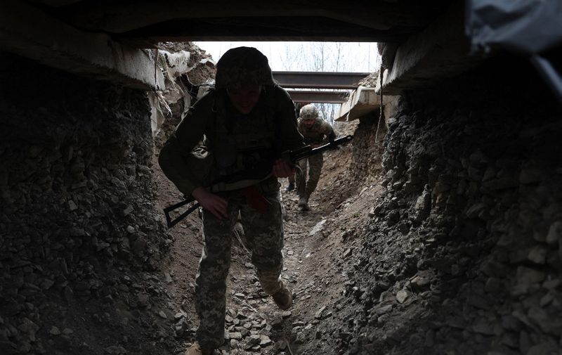 Ukrainian soldiers walk through a tunnel of a trench on the front line with Russian troops in Lugansk region on April 11, 2022. (Photo by Anatolii STEPANOV / AFP)