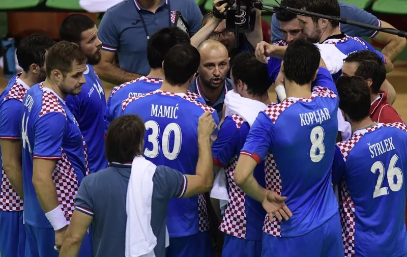 Croatia's coach Zeljko Babic (C) gives instructions to his players durign a time out of the men's quarterfinal handball match Croatia vs poland for the Rio 2016 Olympics Games at the Future Arena in Rio on August 17, 2016. / AFP PHOTO / JAVIER SORIANO