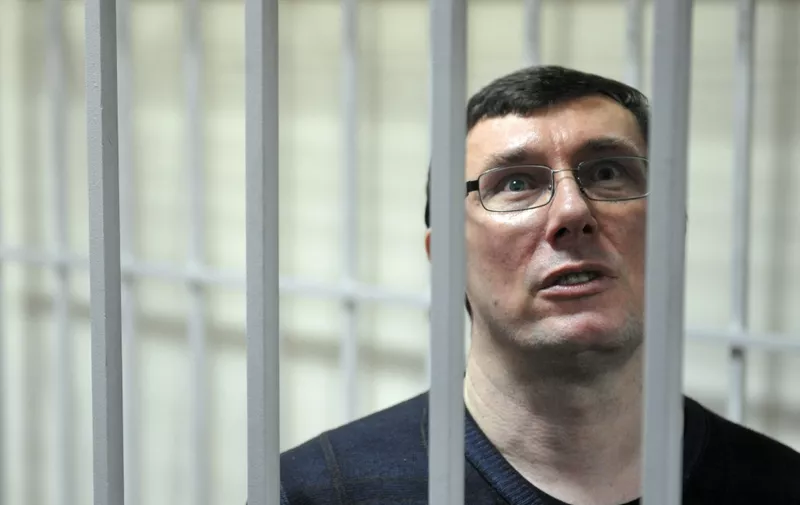 Yuriy Lutsenko, former Ukrainian interior minister ally of the jailed ex-prime minister Yulia Tymoshenko stands in a caged area inside the court during a verdict hearing in Kiev on February 27, 2012.  Lutsenko, who was arrested in December 2010 and has been held in detention ever since, was found guilty by a district court in Kiev of abusing his powers while in office was sentenced to four years in jail in a trial denounced by her supporters as politically motivated.. AFP PHOTO/ SERGEI SUPINSKY (Photo by SERGEI SUPINSKY / AFP)