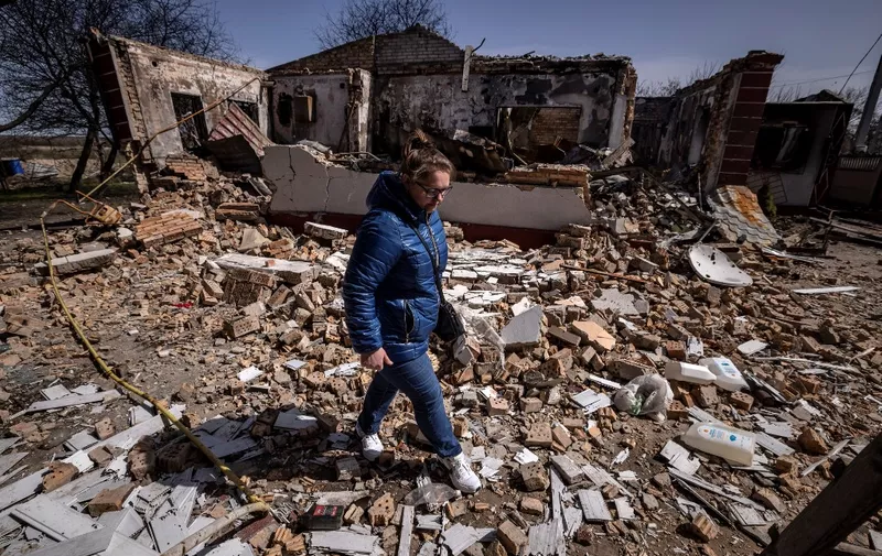 A woman walks among rubble of a destroyed house in Bohdanivka village, northeast of Kyiv, on April 14, 2022, amid Russia's military invasion launched on Ukraine. (Photo by FADEL SENNA / AFP)