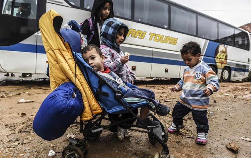 Children wait in front of a bus heading to Belgrade from the southern Serbian town of Presevo on September 11, 2015. A record 5,000 migrants have arrived at Serbia's border with Hungary over the past 24 hours, a television report said on September 10. Some 3,000 of them have already entered into Hungary, the state RTS television said. Most of the migrants are moving through Hungary on their way to Germany and other northern countries where they hope to win asylum. Some 50 buses transporting around 2,500 migrants as well as three trains with around 3,000 others left on September 9 to 10 overnight from Gevgelija, on the Macedonian side of its border with Greece towards Serbia, according to AFP journalists. The EU unveiled plans to take 160,000 refugees from overstretched border states, as the United States said it would accept more Syrians to ease the pressure from the worst migration crisis since World War II. AFP PHOTO / ARMEND NIMANI