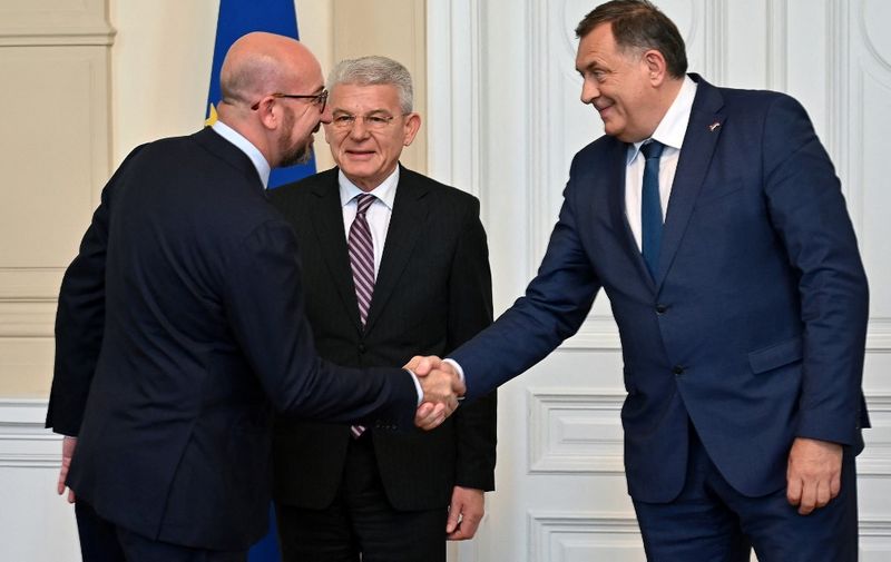 President of the European Council, Charles Michel (L), shakes hands with memberS of Bosnia and Herzegovina's tripartite presidency, Milorad Dodik (R), and Sefik Dzaferovic (C), before an official meeting, in Sarajevo, on May 20, 2022. - Charles Michel is on his first official visit to Bosnia and Herzegovina, as part of the last stop in a regional tour, which also included visits to Serbia and Albania. (Photo by ELVIS BARUKCIC / AFP)