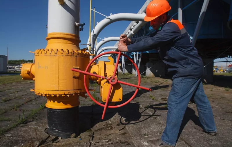 An employee tightens the valve on a pipeline at the Bilche-Volytsko-Uherske underground gas storage facility, the largest in Europe, not far from the village of Bilche village, in the Lviv region of western Ukraine, on May 21, 2014. The European Union called today on Russia to live up to its commitment to ensure continued gas supplies to Europe via Ukraine as long as talks on their future continued. With Russian gas giant Gazprom warning it may halt shipments to Ukraine on June 3 unless its bills are paid, European Commission head Jose Manuel Barroso told Russian President Vladimir Putin it was "imperative" that negotiations continued. AFP PHOTO/ ALEXANDER ZOBIN (Photo by ALEXANDER ZOBIN / AFP)