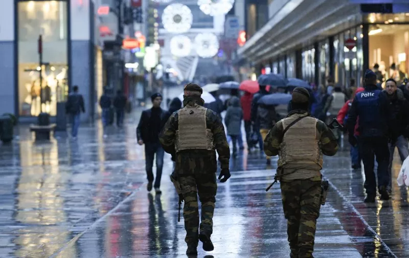 Belgian soldiers patrol the Rue Neuve pedestrian shopping street in Brussels on November 21, 2015. Brussels was on terror lockdown, with a gunman still on the run after the Paris attacks which have rattled nerves throughout Europe. The Belgian capital closed its metro system and shuttered shopping centres as a terror alert was raised to its highest level over reports of an "imminent threat" of a gun and bomb attack similar to the horror seen in Paris last week. AFP PHOTO / JOHN THYS / AFP / JOHN THYS