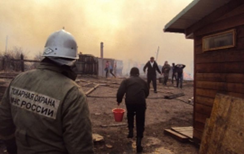 This undated handout picture released by Russia&#8217;s Emergency Ministry on April 12, 2015 shows a firefighter and local residents extinguishing a fire in a village in the region of Khakassia in southeastern Siberia. Fifteen people died and more than 460 sought medical treatment after wildfires caused by warm temperatures and high winds swept through southern [&hellip;]