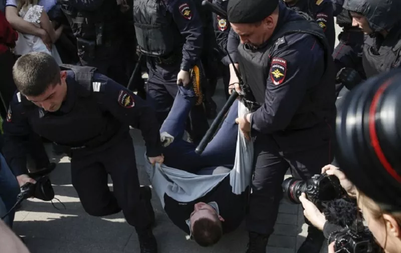 Russian police officers detain a participant of an unauthorized anti-Putin rally called by opposition leader Alexei Navalny on May 5, 2018 in Moscow, two days ahead of Vladimir Putin's inauguration for a fourth Kremlin term.
 / AFP PHOTO / Maxim ZMEYEV