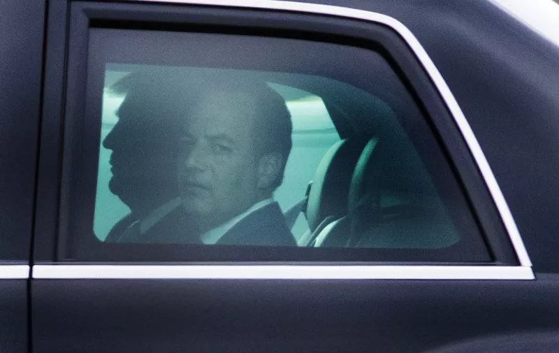 White House Chief-of-Staff Reince Priebus looks out the window of the limo as he rides with US President Donald Trump at Andrews Air Force Base, Maryland, April 13, 2017. / AFP PHOTO / JIM WATSON