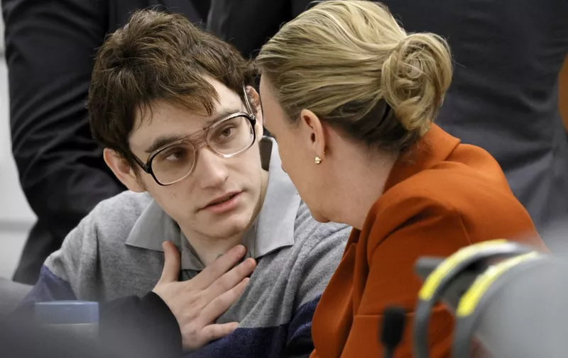 Marjory Stoneman Douglas High School shooter Nikolas Cruz speaks with Assistant Public Defender Melisa McNeill as the verdicts are read in his trial at the Broward County Courthouse in Fort Lauderdale, Florida, on October 13, 2022. - A US jury on Thursday rejected the death penalty for Cruz, who shot and killed 17 people at his former Florida high school, opting instead for life imprisonment without the chance of parole. As the verdict was read, Cruz, wearing a striped sweater and large glasses, stared down expressionless at the defense table while several relatives of the victims in the public gallery shook their heads in disbelief. (Photo by Amy Beth Bennett / POOL / AFP)