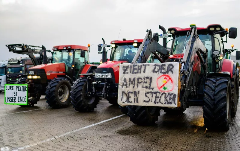 21 December 2023, Lower Saxony, Soltau: Farmers stand together shortly before a protest action not far from the highway. The reason for this is the German government's plans to abolish the agricultural diesel and vehicle tax exemption for agriculture and forestry. Photo: Philipp Schulze/dpa (Photo by PHILIPP SCHULZE / DPA / dpa Picture-Alliance via AFP)