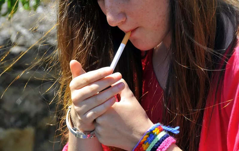ADOLESCENT SMOKING 
Teenager lighting up a cigarette. 

HOUIN / BSIP (Photo by HOUIN / BSIP / BSIP via AFP)
