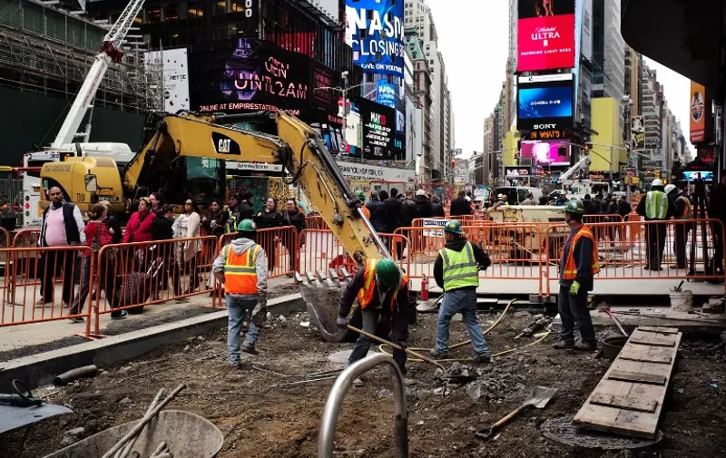 Workers dig to clear cement and soil to rebuild a footpath at the Times Square in New York on May 5, 2016.
An increase in layoffs pushed US claims for unemployment insurance higher last week but the jobs market remains tight, Labor Department data showed. / AFP PHOTO / Jewel SAMAD