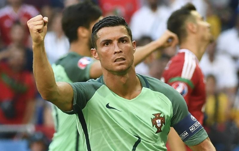 Portugal's forward Cristiano Ronaldo (R) celebrates after scoring a goal  during the Euro 2016 group F football match between Hungary and Portugal at the Parc Olympique Lyonnais stadium in Decines-Charpieu, near Lyon, on June 22, 2016. / AFP PHOTO / PHILIPPE DESMAZES