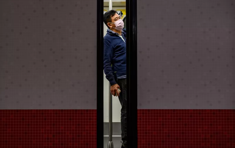 A man wears a face mask as a preventative measure against the COVID-19 coronavirus, as he stands in a train at Mong Kok MTR station in Hong Kong on February 14, 2020. - The death toll from China's virus epidemic neared 1,400 on Friday with six medical workers among the victims, underscoring the country's struggle to contain a deepening health crisis. (Photo by Philip FONG / AFP)