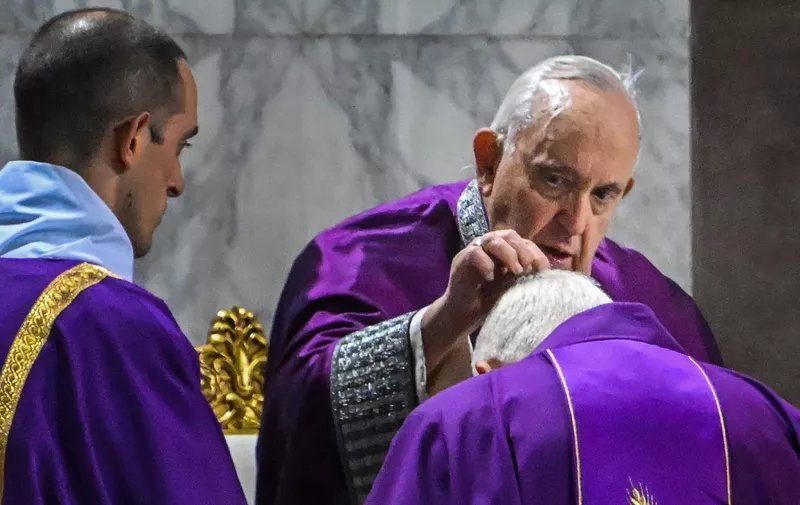 Pope Francis sprinkles the head of a Cardinal with ashes during the celebration of Ash Wednesday mass on February 22, 2023 at the Church of Saint Sabina in Rome. (Photo by Alberto PIZZOLI / AFP)