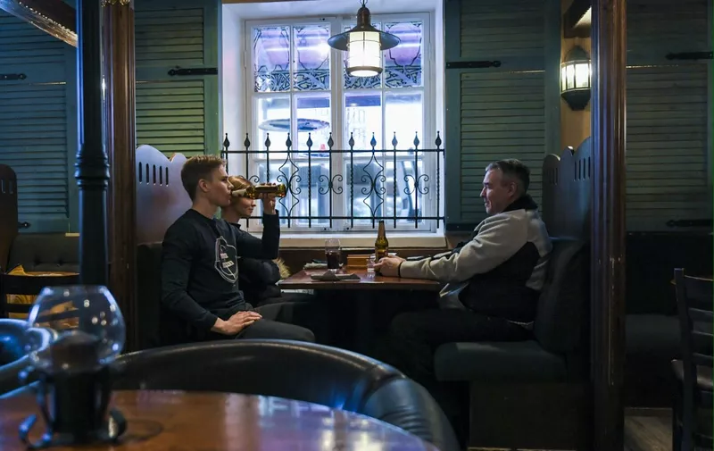 Clients enjoy their beers at the Czech-style pub Vltava, in downtown Helsinki on March 7, 2021, one day before the start of a 3 week long partial lockdown, for the worst hit areas by the novel coronavirus Covid-19. (Photo by Markku Ulander / Lehtikuva / AFP) / Finland OUT