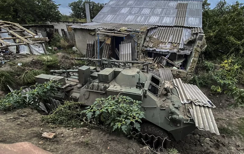 This photograph taken on September 11, 2022, shows an abandoned Russian armoured personnel carrier near a village on the outskirts of Izyum, Kharkiv Region, eastern Ukraine, amid the Russian invasion of Ukraine. - Ukrainian forces reported on September 12, 2022, that their lightning counter-offensive took back more ground in the past 24 hours, as Russia replied with strikes on some of the recaptured ground. The territorial shifts were one of Russia's biggest reversals since its forces were turned back from Kyiv in the earliest days of the nearly seven months of fighting, yet Moscow signalled it was no closer to agreeing a negotiated peace. (Photo by Juan BARRETO / AFP)