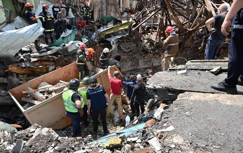 EDITORS NOTE: Graphic content / Rescuers carry the body of a woman recovered from the rubble of the House of Culture destroyed by a Russian rocket attack, in Chuguiv, on July 26, 2022, amid the Russian invasion of Ukraine. (Photo by SERGEY BOBOK / AFP)