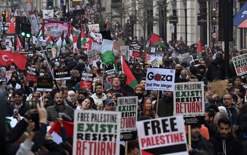 People walk down Regent Street as they take part in a 'March For Palestine', part of a pro-Palestinian national demonstration, in London on October 14, 2023, organised by Palestine Solidarity Campaign, Friends of Al-Aqsa, Stop the War Coalition, Muslim Association of Britain, Palestinian Forum in Britain and CND. British Prime Minister Rishi Sunak called on Israel Friday to take "every possible precaution to protect civilians" in its response to last weekend's deadly attack by Hamas. (Photo by JUSTIN TALLIS / AFP)