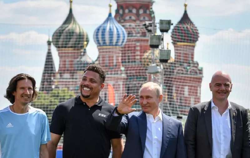 Russia's President Vladimir Putin (2nd R), FIFA President Gianni Infantino (R), former footballer Ronaldo (2nd L) and Russia's Football Union's anti-racism inspector Alexei Smertin pose for a picture as they attend the opening of an exhibition soccer match at the World Cup Football Park at the Red Square in Moscow on June 28, 2018. / AFP PHOTO / Yuri KADOBNOV