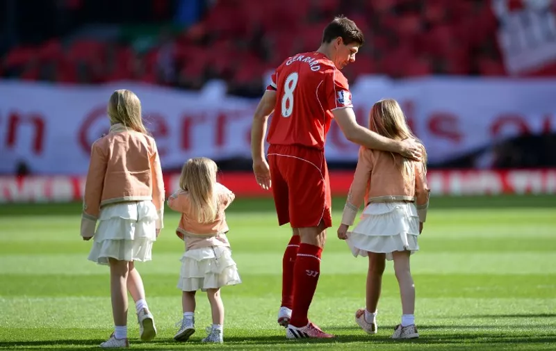 Liverpool's English midfielder Steven Gerrard walks onto the pitch with his daughters Lilly-Ella , Lourdes and Lexie at the start of the English Premier League football match between Liverpool and Crystal Palace at the Anfield stadium in Liverpool, northwest England, on May 16, 2015. 