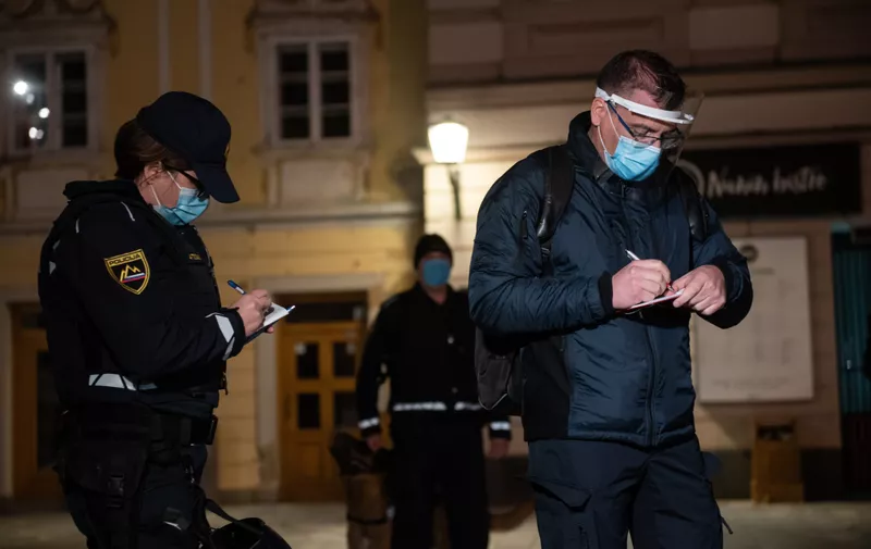 Police officers wearing facemasks are seen checking the documents of a protester defying the night curfew enforcement.
Slovenia redeclared an epidemic and took strict measures to prevent the spread of coronavirus (Covid-19). A 9pm to 6am curfew has been enforced for the first time.,Image: 565019880, License: Rights-managed, Restrictions: *** World Rights ***, Model Release: no