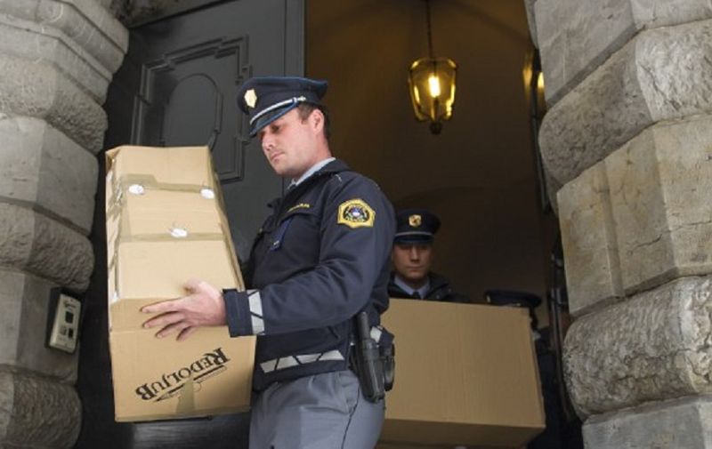 Police carry boxes of evidence from the Ljubljana City Hall during a corruption investigation on September 27, 2012. Six individuals of the centre-left mayor's entourage were arrested by Slovenian police during searches at their homes carried out as part of a corruption investigation which began a year and a half ago, Slovenian authorities announced today, though they did not say if Mayor Jankovic was among those arrested. According to Slovenian media reports, the Slovenian tax authorities (DRUS) suspect Mayor Jankovic of abuses of power, falsification of commercial documents and fraud to creditors. AFP PHOTO / JURE MAKOVEC