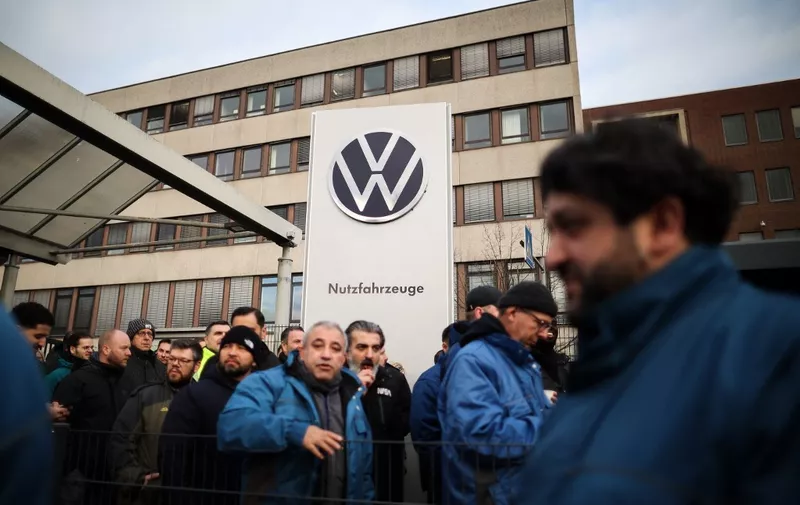 Employees of German car maker Volkswagen (VW) leave the exit gate before they demonstrate outside the commercial cars plant of VW in Hanover, northern Germany, on December 2, 2024 as thousands of Volkswagen workers go on strike all over Germany in an escalating industrial dispute at the crisis-hit German auto giant with thousands of jobs at stake. VW has been hit hard by high manufacturing costs at home, a stuttering shift to electric vehicles and tough competition in key market China. It has announced a plan to cut billions of dollars in costs. (Photo by Ronny HARTMANN / AFP)