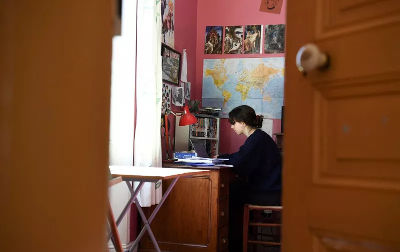 A high school student does homework via the website of the CNED (Centre national d'éducation à distance - National Center for Distance Education) at her home in Chisseaux near Tours on March 27, 2020, on the eleventh day of a lockdown in France to stop the spread of the novel coronavirus COVID-19. (Photo by Alain JOCARD / AFP)