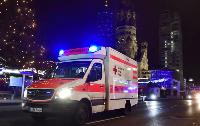 An ambulance car stands at the site where a truck crashed into a christmas market in Berlin, on December 19, 2016 killing at least one person and injuring at least 50 people. - Ambulances and police rushed to the scene after the driver drove up the pavement of the market in a central square popular with tourists less than a week before Christmas, in a scene reminiscent of the deadly truck attack in Nice. (Photo by John MACDOUGALL / AFP)