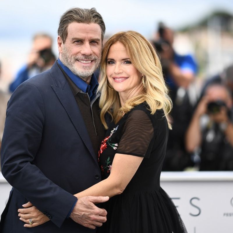 (FILES) In this file photo taken on May 15, 2018 US actor John Travolta (L) and his wife US actress Kelly Preston pose during a photocall for the film "Gotti" at the 71st edition of the Cannes Film Festival in Cannes, southern France. - Kelly Preston, US actress and wife of US actor John Travolta, died after a battle with breast cancer at the age of 57, US media reported on July 12, 2020. (Photo by Anne-Christine POUJOULAT / AFP)