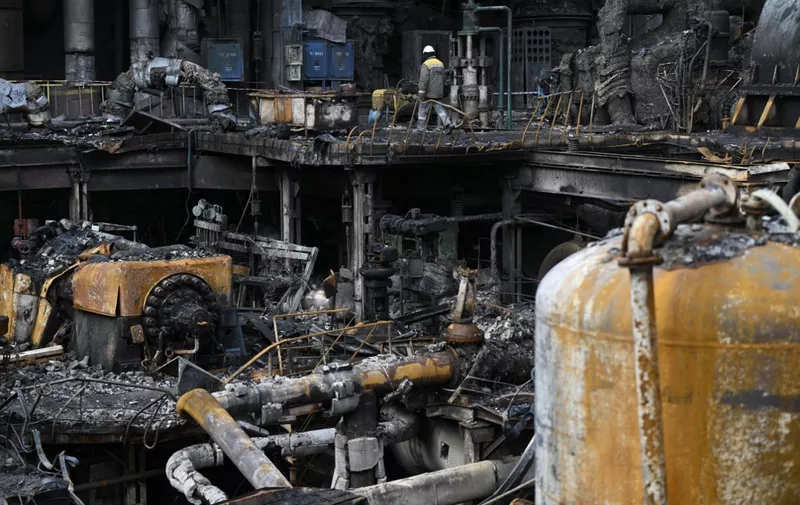 A worker walks past scorched equipment in a turbine hall at a power plant of energy provider DTEK, destroyed after an attack, in an undisclosed location in Ukraine on April 19, 2024, amid the Russian invasion of Ukraine. Russia was able to destroy a key power plant serving Kyiv because Ukraine ran out of defensive missiles, President Volodymyr Zelensky said on April 16, 2024. For three-and-a-half weeks, Russia has launched near continuous strikes on Ukraine's power grid, leaving over a million people without electricity. (Photo by Genya SAVILOV / AFP)